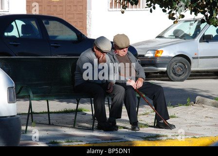 Drei ältere spanische Männer sitzen auf einer Bank im Chat, Canillas de Aceituno, Costa Del Sol, Provinz Malaga, Andalusien, Spanien. Stockfoto