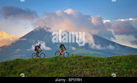 Professionelle Mountainbiker Hans Rey und Brian Lopes am Vulkan Mount Mayon, Philippinen Stockfoto