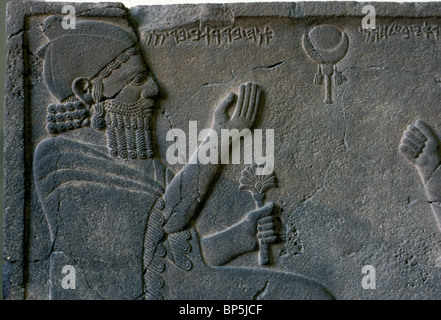 ORTHOSTAT RELIEF DES KÖNIGS BARREKUB VON ZINJIRLI UM 750 V. CHR. AUS. DER KÖNIG SITZT AUF EINEM PRÄCHTIG GESCHMÜCKTEN THRON A Stockfoto