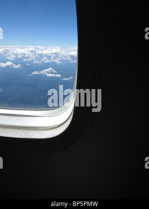 Ein Passagier Blick auf ein Flugzeug Fenster außerhalb Tageslicht mit blauen Himmel und Wolken Stockfoto