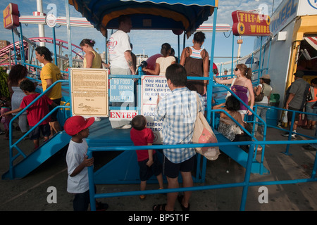 Ein Vater prüft die Höhe seines Sohnes zu sehen, wenn er groß ist genug, um auf die Tilt-A-Whirl gehen auf Coney Island in Brooklyn fahren Stockfoto