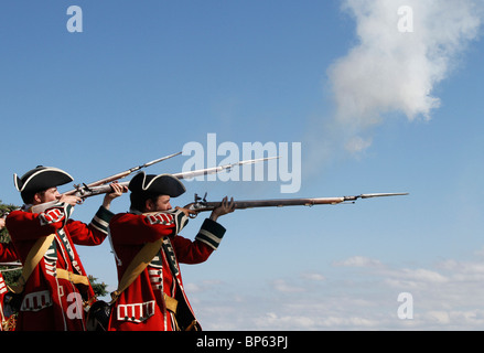 Zwei englische Redcoats-Soldaten feuern Musketen auf die britische Armee Fort George, eine historische Nachbespielungsveranstaltung am 2010. August Inverness-Shire, Schottland, Großbritannien Stockfoto