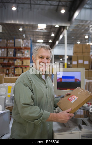 Fröhlicher Mensch im Auslieferungslager Stockfoto