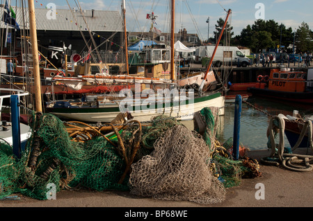 traditionelle Auster Jollen Ohrfeigen und Fischernetze in Whitstable Hafen Kent England uk Stockfoto