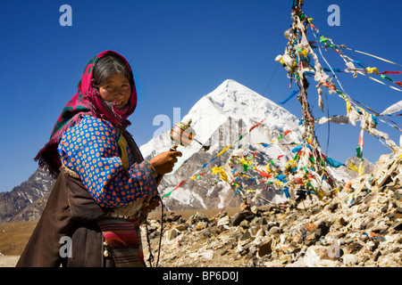 Tibetische Pilger dreht ihr Mani Gebetsmühle auf Mila Bergpass (5300m) Stockfoto