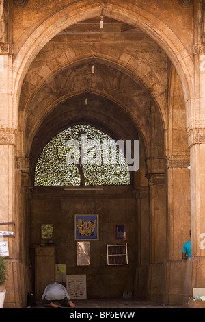 Ein Mann betet vor dem berühmten Jali-Werk auf dem Bildschirm in der Sidi Saiyyed Moschee in Ahmedabad, Gujarat, Indien. Stockfoto