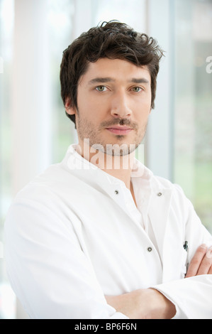 Männlichen Arzt stehend mit seine Arme verschränkt Stockfoto