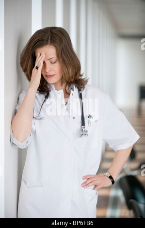 Ärztin, die unter Kopfschmerzen leiden Stockfoto