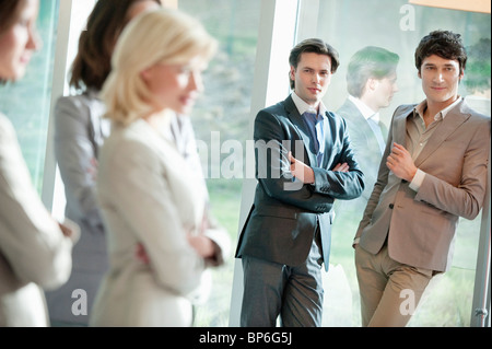Zwei Geschäftsleute, die ihre weiblichen Kollegen betrachten Stockfoto