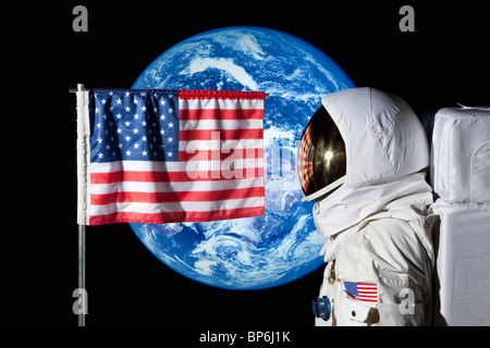 Ein Astronaut durch eine amerikanische Flagge mit der Erde im Hintergrund stehen Stockfoto