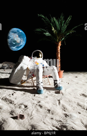 Ein Astronaut auf dem Mond zum Entspannen in einem Strandkorb Stockfoto