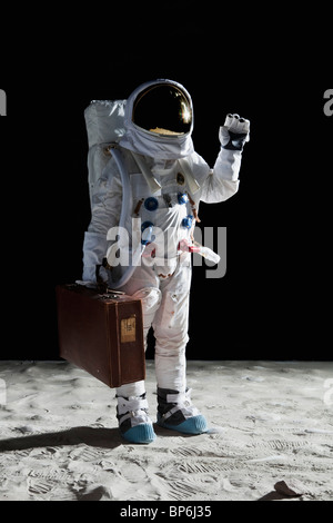 Ein Astronaut auf dem Mond mit einem Koffer und winken Stockfoto