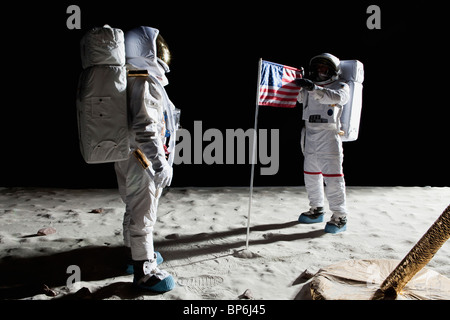 Zwei Astronauten auf dem Mond, eine amerikanische Flagge zwischen Ihnen Stockfoto