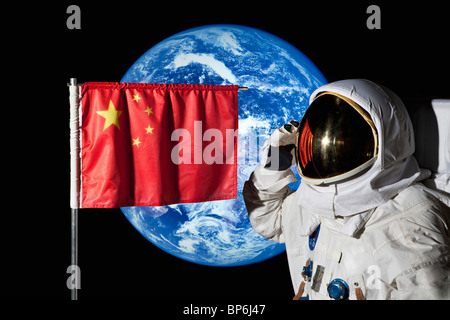 Ein Astronaut, salutieren, eine chinesische Flagge mit der Erde im Hintergrund Stockfoto