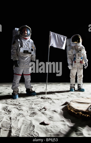 Zwei Astronauten auf dem Mond, eine leere weiße Fahne dazwischen Stockfoto