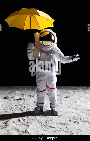 Ein Astronaut auf dem Mond mit einem Regenschirm Stockfoto