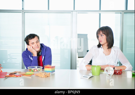 Geschäftsmann und eine Geschäftsfrau, die zusammen mit Essen am Tisch sitzen Stockfoto