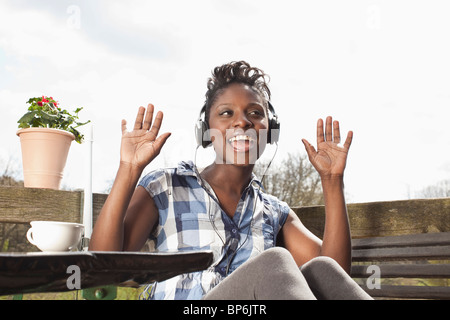 Eine Frau mit Kopfhörern, singen und tanzen Stockfoto