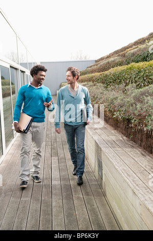 Zwei Freunde gehen zusammen auf einem Holzsteg Stockfoto