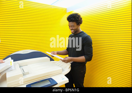 Geschäftsmann mit einem Kopiergerät in einem Büro Stockfoto