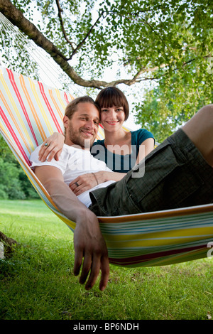 Ein junges glückliches Paar zusammen in einer Hängematte liegend Stockfoto