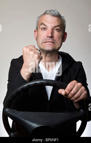 Ein Mann seine Faust hinterm Lenkrad Auto schütteln Stockfoto