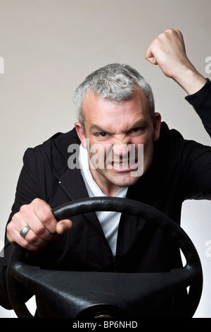 Ein Mann seine Faust hinterm Lenkrad Auto schütteln Stockfoto