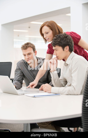 Geschäftsfrau mit zwei Geschäftsleute, die in einem Büro arbeiten Stockfoto
