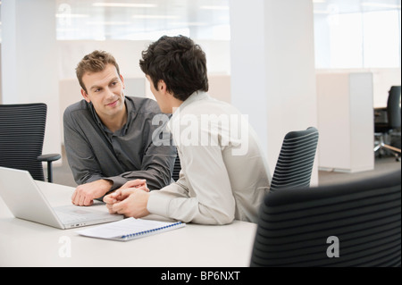 Zwei Geschäftsleute diskutieren miteinander in einem Büro Stockfoto