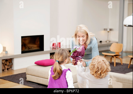 Frau, die ihren Enkeln eine Topfpflanze verleihen Stockfoto