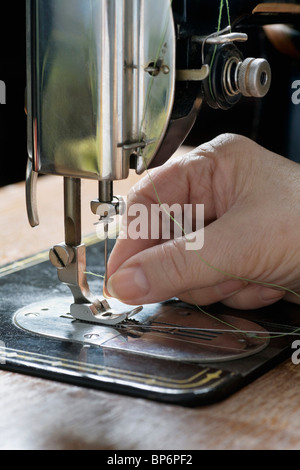 Eine Frau Einfädeln einer Nadel auf eine Nähmaschine, Detail von hand Stockfoto