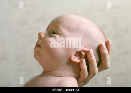 Eine Mutter die Hand wiegte ihr Baby Kopf Stockfoto