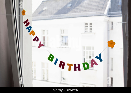 Ein HAPPY BIRTHDAY-Zeichen vor einem Fenster hängen Stockfoto