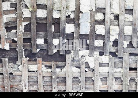 Die alte Betonmauer wird zerstört. Das hölzerne Skelett ist entblößt. Stockfoto