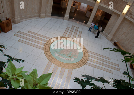 Führung der New Mexico State Capitol Gebäude in Santa Fe, zeigt das Sonnensymbol der Zia auf dem Marmorboden Rotunde Stockfoto