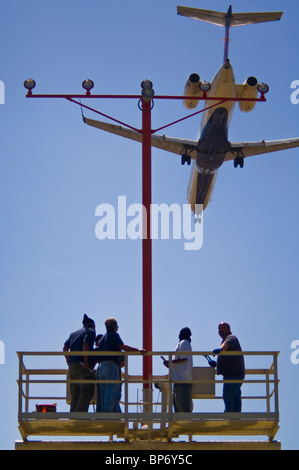 Menschen, die Arbeiten am Start-und Landebahn Anflugbefeuerung unter Jet-Flugzeug landet auf dem Los Angeles International Airport LAX, California Stockfoto