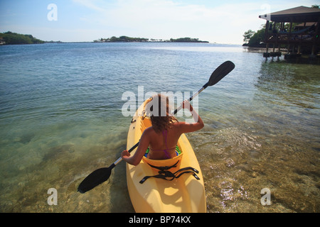 Roatan, Bay Islands, Honduras; Eine junge Frau paddeln eine Kajak an Anthonys Key Resort Stockfoto