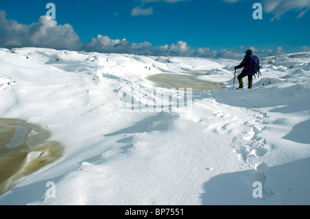 Ein Wanderer auf dem gefrorenen Kinder Scout-Plateau im Winter, in der Nähe von Hayfield, Peak District, Derbyshire, England, UK Stockfoto