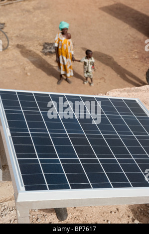 Westafrika Mali Sonnenkollektor auf dem Dach des solar powered Akku aufladen Station im Dorf Dialkoro, Frau mit Kind Stockfoto