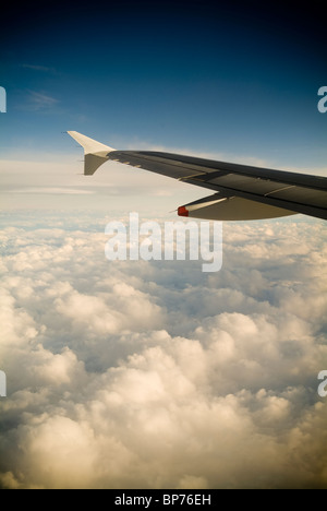Ein Passagiere Blick auf ein Flugzeug Flügel hoch über den Wolken. Stockfoto