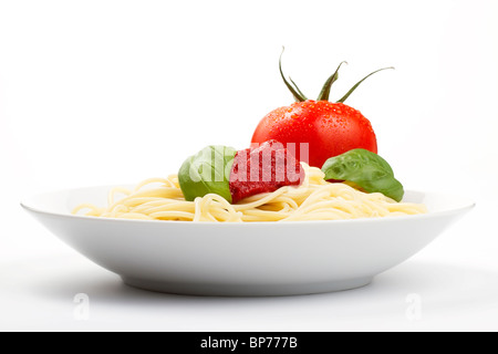 Spaghetti in einem Teller mit Tomaten, Basilikum und Soße Stockfoto