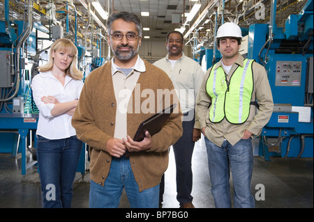 Gruppe von Menschen, die Arbeit in Fabrik Zeitung, Porträt Stockfoto