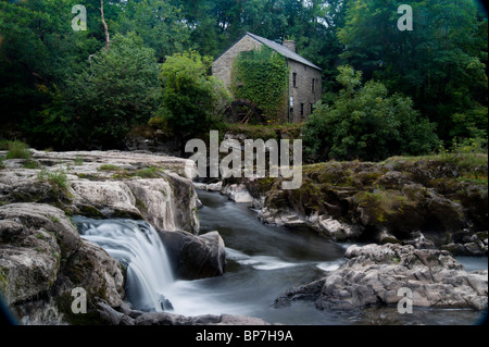 Das Wasser fällt auf Cenarth Boden fällt von Wales mit der alten Wassermühle in den Rücken Stockfoto