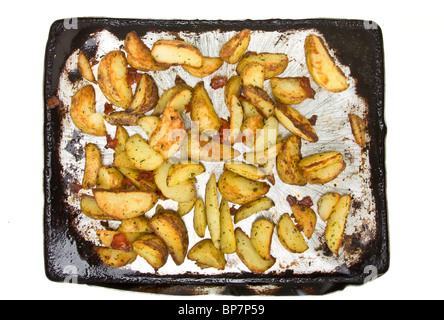 Würzige Kartoffelspalten mit Chorizo-Wurst auf Backblech aus dem Ofen nehmen. Stockfoto