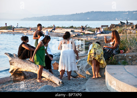 Gruppe von großen schwarzen afrikanischen amerikanischen Frauen Freunde unter den unterschiedlichsten Menschen genießen den Strand bei Sonnenuntergang in Edmonds, Washington Stockfoto