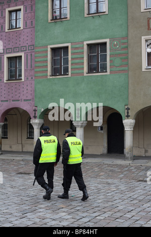 Zwei Polizisten zu Fuß durch den alten Marktplatz in Poznan, Polen Stockfoto