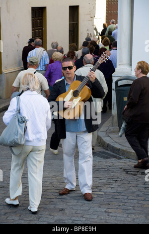 Busker / Musiker mit Gitarre spielt Musik für Touristen / Touristen: typische Sevilla Straße / Hof / Court yard. Sevilla, Spanien Stockfoto