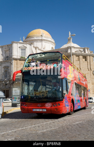 Sightseeing-Bus unterwegs in alten Stadt Cadiz vorbei an der Kathedrale, mit seiner goldenen Kuppel. Cadiz. Spanien. Stockfoto