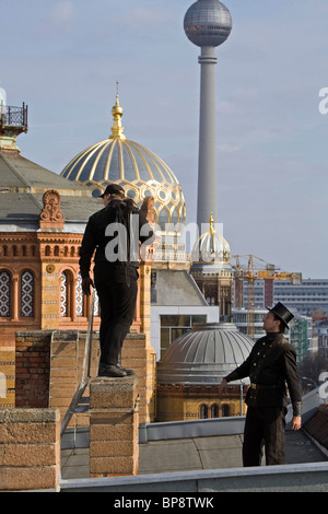 Schornsteinfeger steht auf Dach, Kuppel der neuen Synagoge im Hintergrund, Berlin, Deutschland Stockfoto