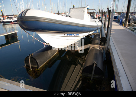 Schlauchboot Rib Boot auf hydraulischen Bootslift neben einem schwimmenden Ponton in einer Marina in Großbritannien Stockfoto